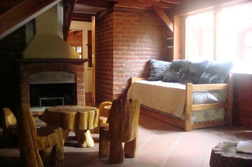 a living room with a bed and a fireplace at Cabañas Lucero del Bosque in San Carlos de Bariloche