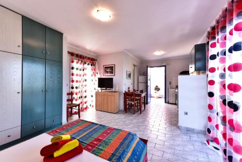 a living room with a bed and a kitchen at Aeolos Studios Kefalonia in Khelmáta