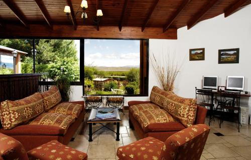 a living room with couches and a large window at Hotel Sierra Nevada in El Calafate