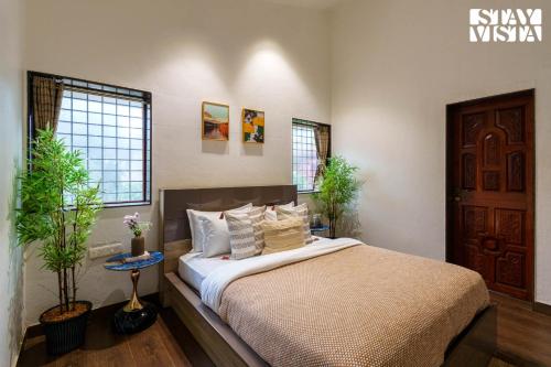Un dormitorio con una cama con sábanas y almohadas blancas. en StayVista at Monte Blu with Views, Pool, Terrace, en Āmbavna