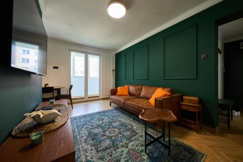 Una sala de estar con paredes verdes y un sofá. en Apartament 500 metrów do zamku 2, en Malbork