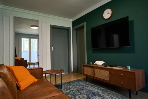 Una sala de estar con un sofá y un televisor en una pared. en Apartament 500 metrów do zamku 2, en Malbork