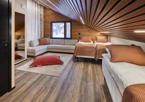 a living room with two beds and a couch at Villa Lux B by Aavalevi Holidays in Levi