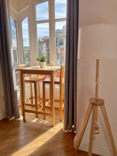 une table et des chaises dans une pièce avec une fenêtre dans l'établissement Apt in Villa Française, à Mers-les-Bains