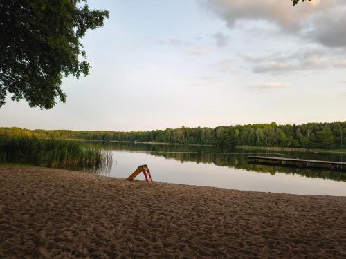 a red object sitting on the shore of a lake at Apartament w Tarnowie Jeziernym in Tarnów Jezierny