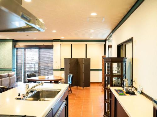 a kitchen with a sink and a living room at Haruhoo Resort ISHIGAKI in Ishigaki Island
