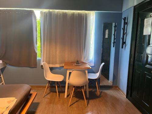 una stanza con un tavolo, sedie e un letto di Blue studio a Néa Michanióna