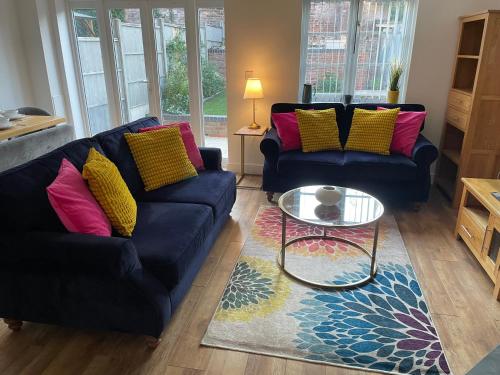 a living room with two couches and a glass table at Pippin Cottage central Bewdley 2 parking spaces in Bewdley