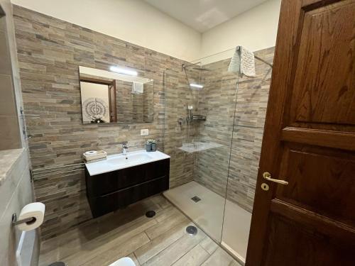 a bathroom with a sink and a glass shower at INFORMIS B&B in Capua