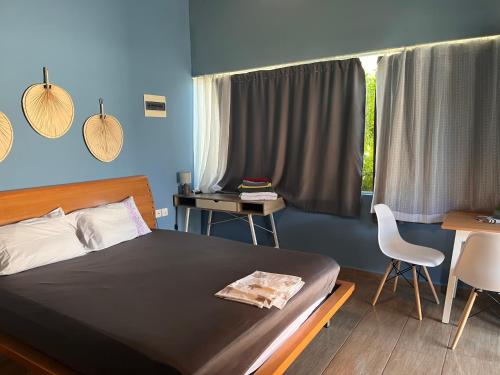 una camera da letto con un letto, una scrivania e una finestra di Blue studio a Néa Michanióna
