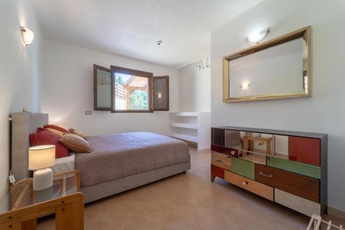 a bedroom with a bed and a dresser and a television at Residence del Golf in Cuile Pazzoni