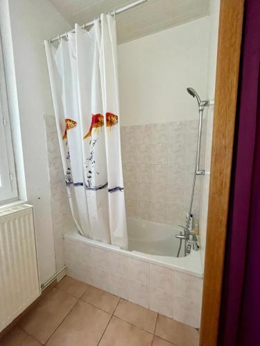 La salle de bains est pourvue d'une baignoire avec rideau de douche. dans l'établissement Apt in Villa Française, à Mers-les-Bains