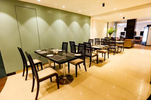a restaurant with tables and chairs in a room at Spree Manor Hotel in Aurangabad