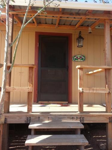 a front porch of a house with a black door at Vinofilia Wine Country Inn in Valle de Guadalupe