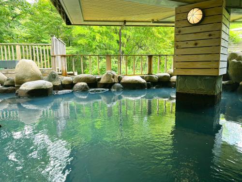 a pool of water with a clock on top of it at Hotel Floracion Nasu in Nasu