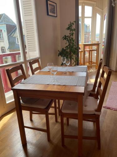 - une table en bois avec des verres à vin dans l'établissement Apt in Villa Française, à Mers-les-Bains