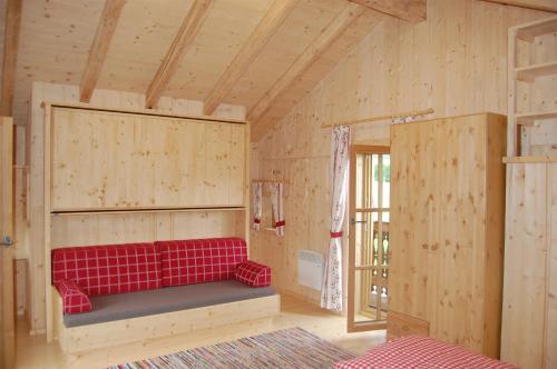 ein rotes Sofa in einem Holzzimmer mit Fenster in der Unterkunft Chalet Steinerner Meerblick in Saalfelden am Steinernen Meer