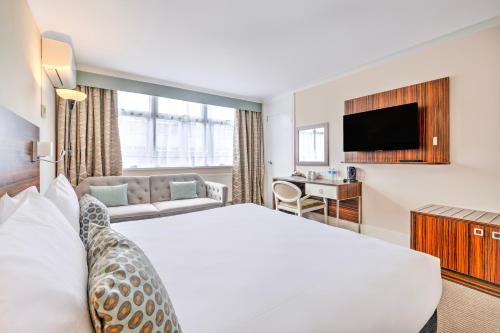 a hotel room with a large bed and a television at Palms Hotel & Retreat By Palette London Romford in Hornchurch