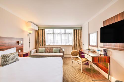 a hotel room with a bed and a television at Palms Hotel & Retreat By Palette London Romford in Hornchurch