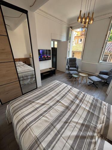 une chambre avec un grand lit et un salon dans l'établissement L'Atelier D'AIX, à Aix-en-Provence