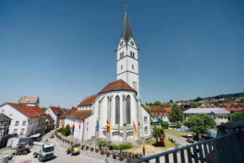 a large white church with a steeple in a town at Das Adler in Markdorf