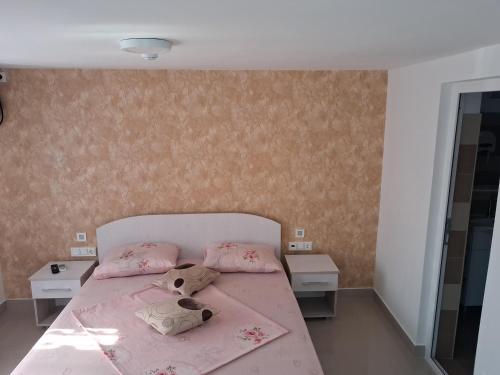 a bedroom with a bed with pink sheets and pillows at Casa Elena in 2 Mai