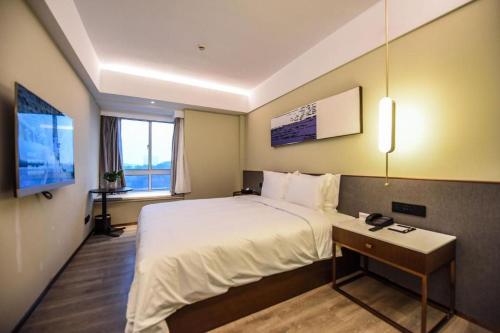 a hotel room with a large bed and a window at AURAYA BY SUNING NANJING XUZHUANG in Nanjing