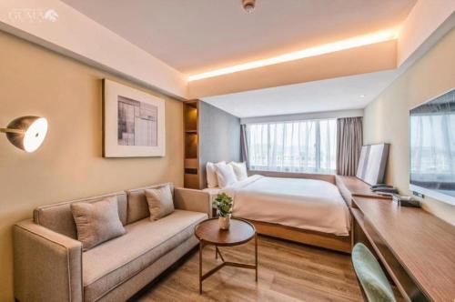 a hotel room with a bed and a couch at AURAYA BY SUNING NANJING XUZHUANG in Nanjing