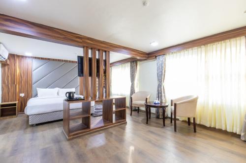 a hotel room with a bed and a table and chairs at Hotel Classic Plaza, Simara in Simra