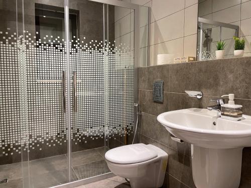 a bathroom with a shower and a toilet and a sink at Double Key by HR in Amman