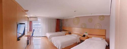a hotel room with two beds and a flat screen tv at GreenTree Inn Beijing Shunyi Fengbo Metro Station in Beijing