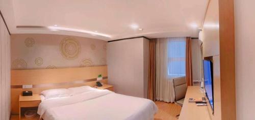 a bedroom with a large white bed and a television at GreenTree Inn Beijing Shunyi Fengbo Metro Station in Beijing