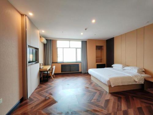 a bedroom with a bed and a desk and a television at 7 Days Inn Harbin Medical University First Affiliated Hospital in Harbin