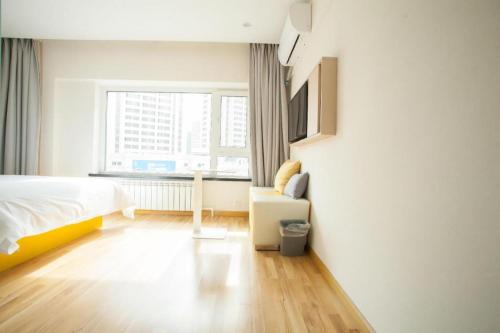 a white bedroom with a bed and a window at 7 Days Inn Harbin West Railway Station in Harbin