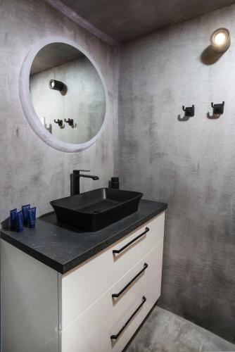 a bathroom with a black sink and a mirror at CitySoul Apartment with Balcony in Thessaloniki