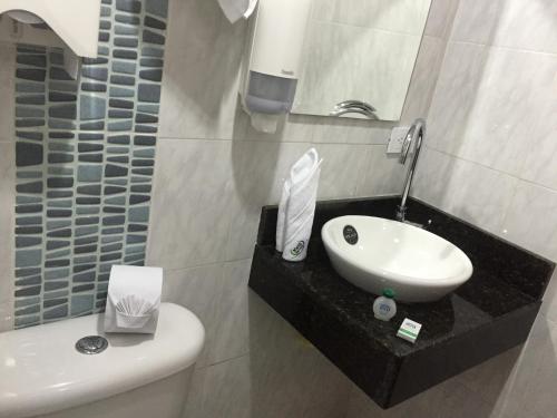 a bathroom with a sink and a toilet and a mirror at Hotel Sipa in Duitama