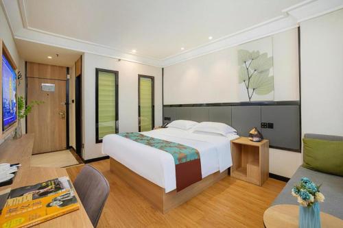 a bedroom with a large white bed and a couch at GreenTree Inn Puyang Pushang Huanghe Road in Puyang