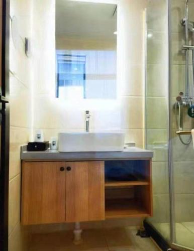a bathroom with a sink and a shower at GreenTree Inn Puyang Pushang Huanghe Road in Puyang