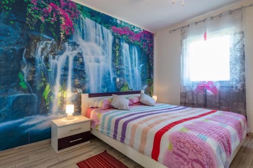 KrmedにあるVilla Roža, a beautiful villa with pool close to the beachのベッドルーム1室(ベッド1台付)、滝の壁画