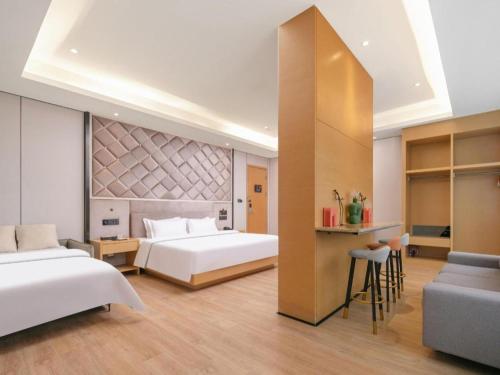 a hotel room with two beds and a bar at Lavande Hotel Wuhan Huanghelou Branch in Wuhan