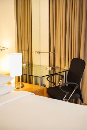 a bedroom with a bed and a glass table and chairs at Hyatt Hyderabad Gachibowli in Hyderabad