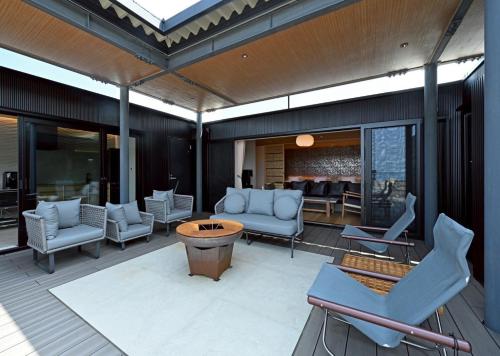 an outdoor patio with chairs and a table at 汐汲浜シーサイドヴィラ浜つづり in Miyazu