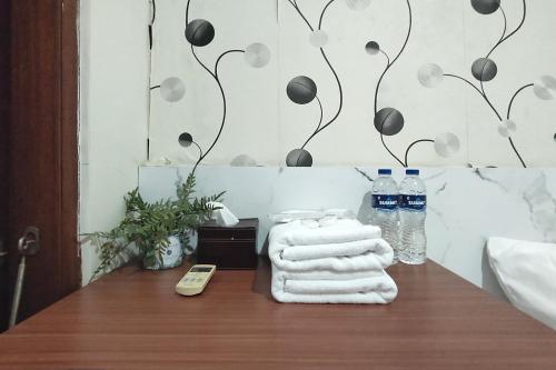 un bagno con asciugamani e bottiglie d'acqua su un tavolo di INNCA - Villa Jatidiri, Semarang a Jatingaleh