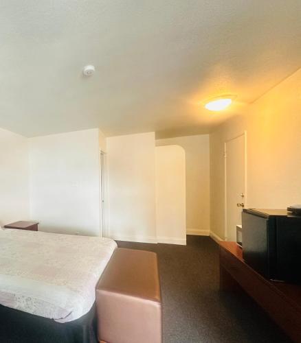 a room with a bed and a television in it at Rogue Valley Inn in Medford
