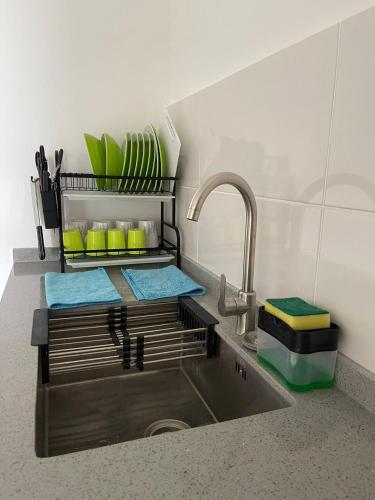 a kitchen counter with a sink with dishes and a faucet at 7-06 Kenny Hill Residence 1 Kuching in Gua Sai