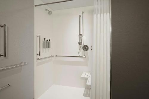a white bathroom with a shower and a tub at Courtyard by Marriott Billings in Billings