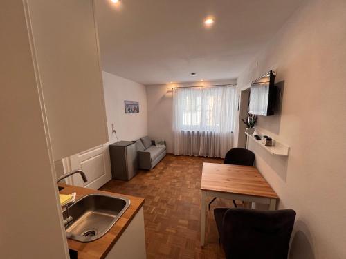 a small apartment with a kitchen and a table at Ferienwohnung Scheuring EG in Nordheim