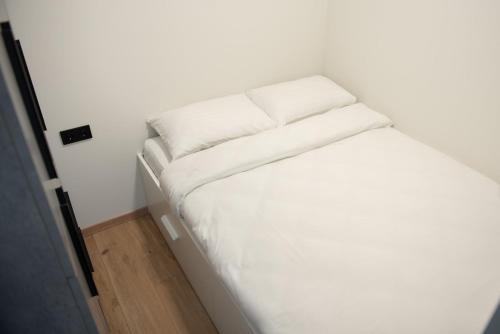 Cette petite chambre comprend un lit blanc. dans l'établissement Sunlit City Loft- Prime Views, à Vilnius
