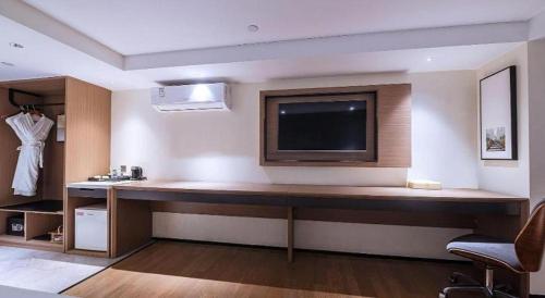 a room with a desk with a flat screen tv at Zhongshan Louis Hotel in Zhongshan