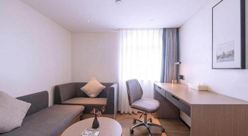 a small living room with a couch and a desk at Zhongshan Louis Hotel in Zhongshan